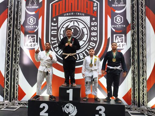 Atletas do projeto no pódio de um campeonato de jiu-jitsu, com medalhas